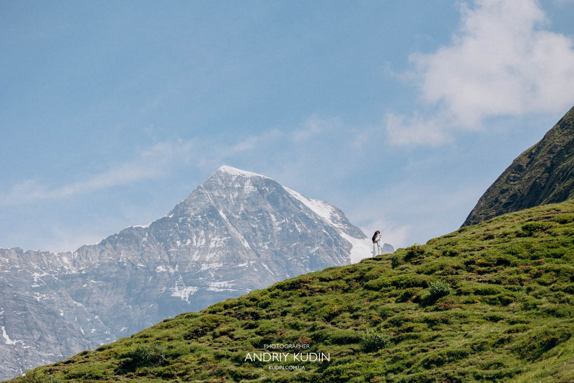 Couple embracing after a proposal photographed by a Switzerland proposal photographer. Interlaken proposal with panoramic mountain scenery.