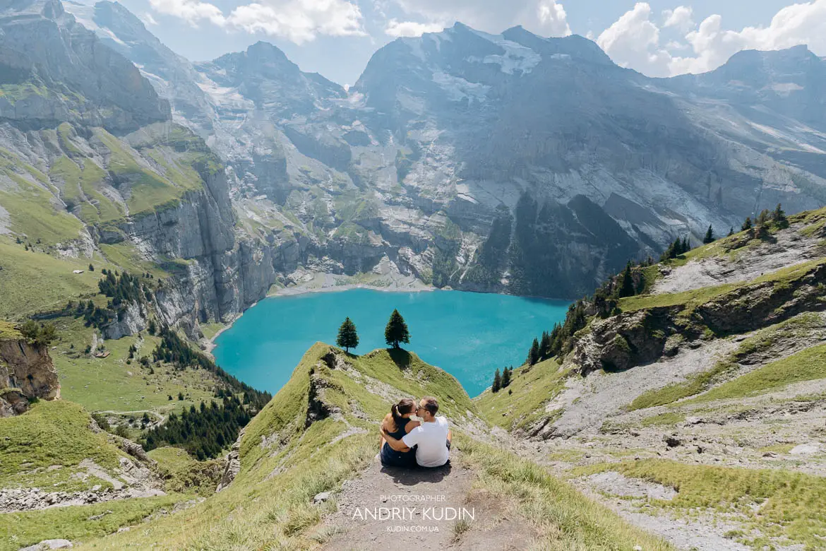 Holden and Misha sitting at the famous cliff edge viewpoint above Lake Oeschinensee