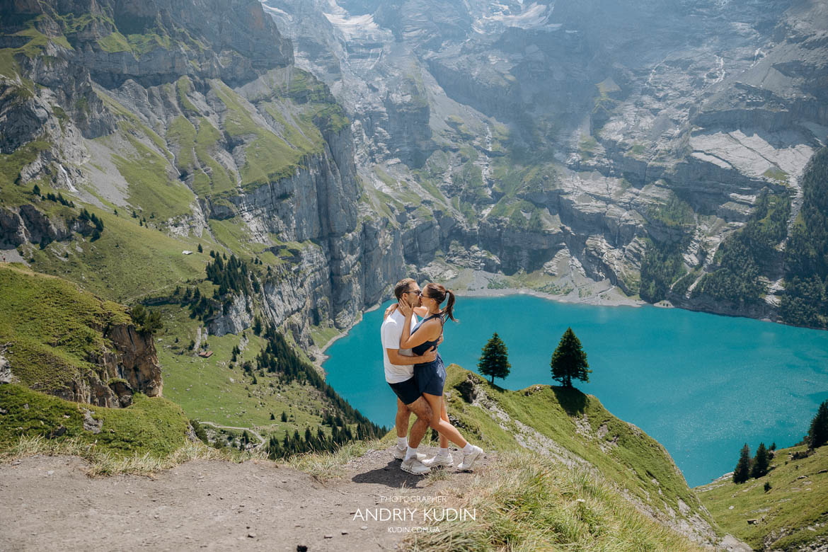 Romantic couple kissing at Oeschinensee viewpoint Romantic couple kissing on a viewpoint overlooking Oeschinensee lake in Bernese Oberland by switzerland proposal photographer