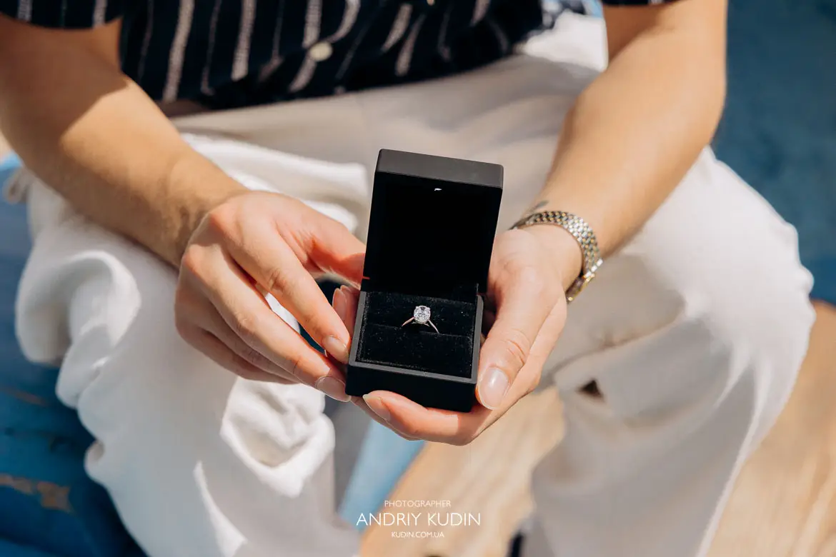 Taylor showing her custom designed engagement ring with Swiss mountains background