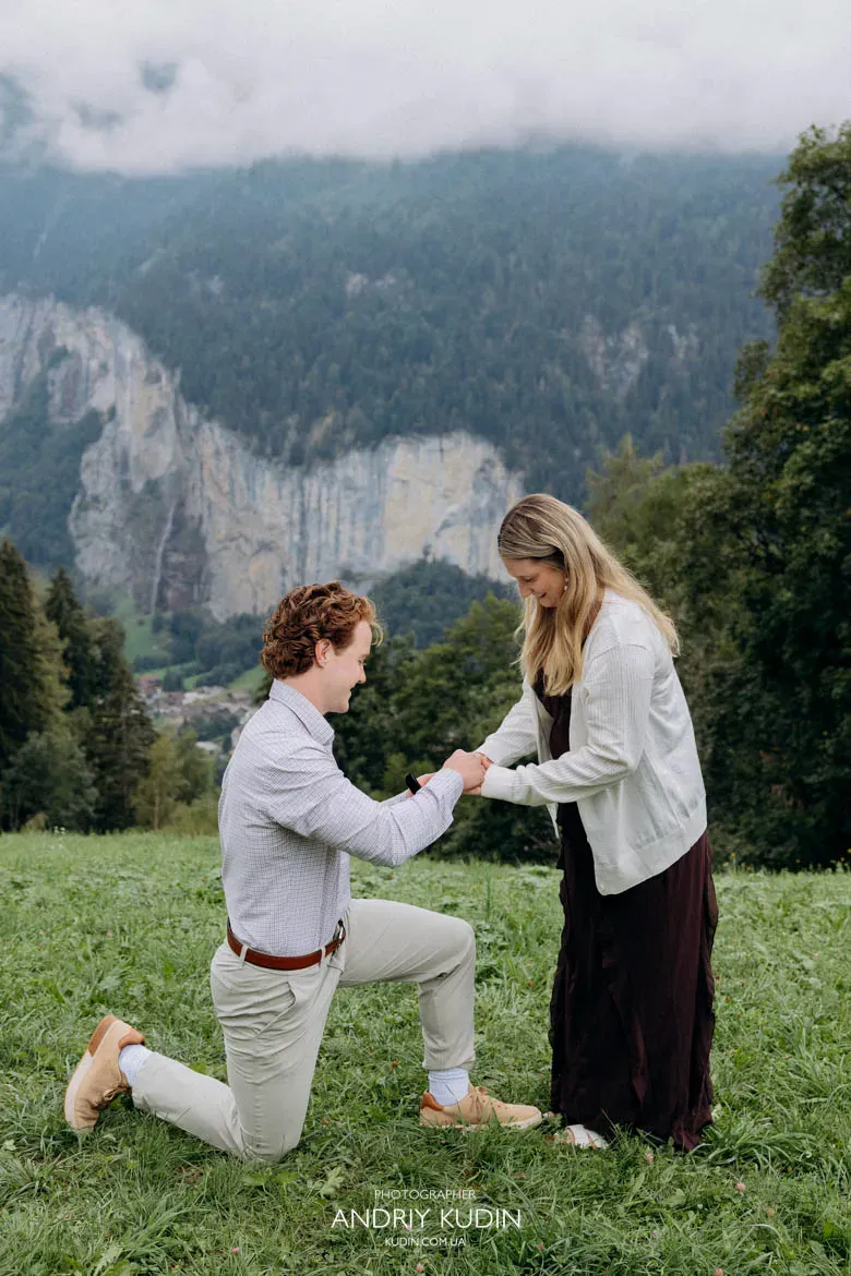 Austin proposing on one knee to Elizabeth during a surprise engagement session in Lauterbrunnen Valley