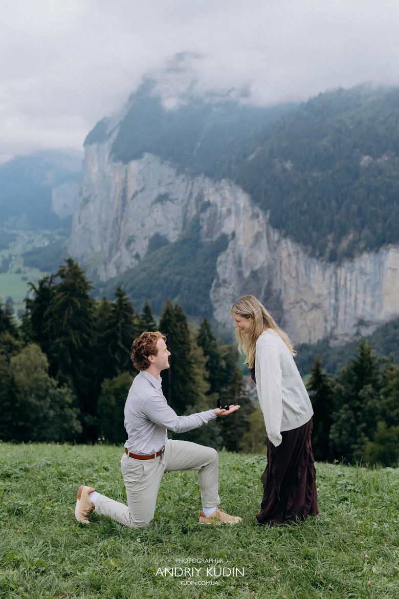 Surprise marriage proposal in Lauterbrunnen Valley surrounded by misty cliffs captured by switzerland proposal photographer.