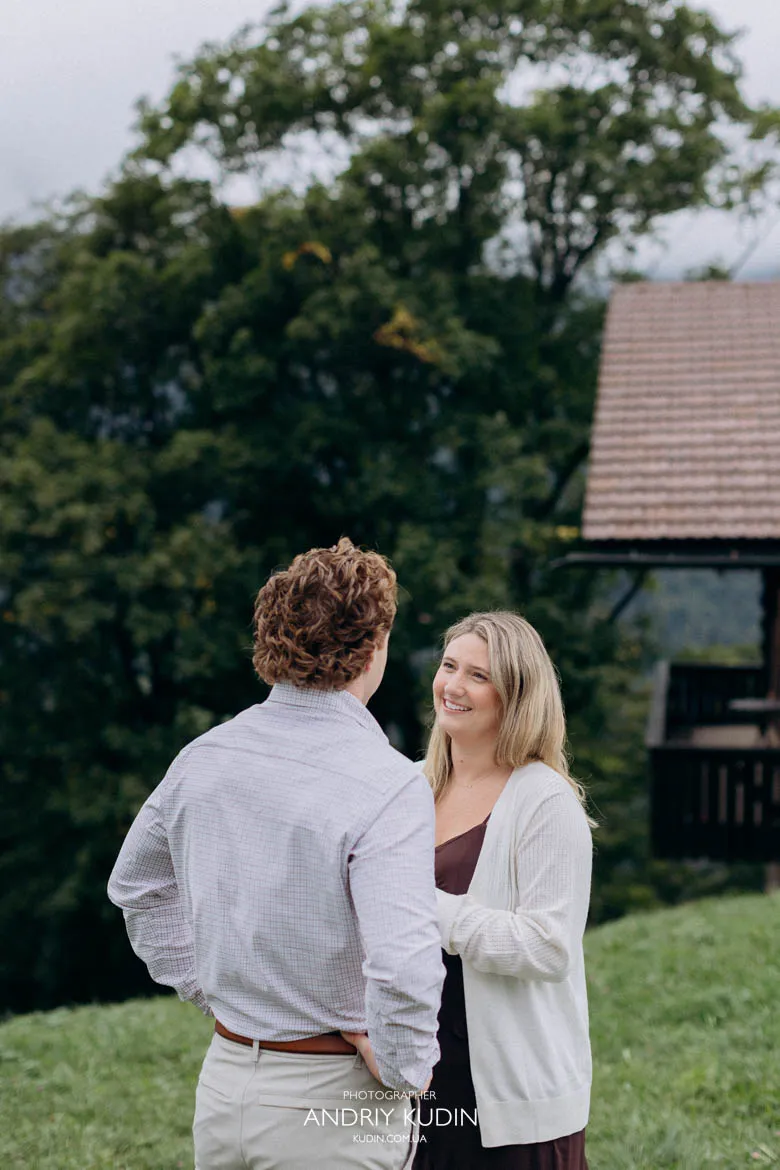 Engaged couple standing in alpine meadow near traditional chalet in Lauterbrunnen. Photo by switzerland proposal photographer.